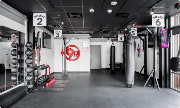 The gym boasts a streamlined franchise buildout featuring, punching bags, weights, and other fitness equipment. Motivational posters and mirrors adorn the walls, inspiring every workout.